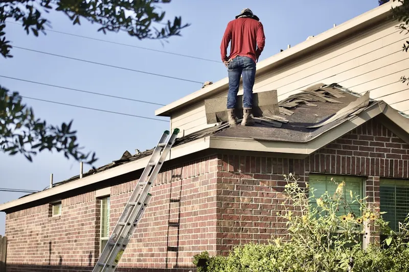 Professional roofer working on a residential roof in Huntington by the Campus